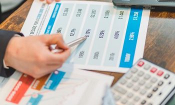 Close-up of financial documents with charts and a calculator used for business analysis.